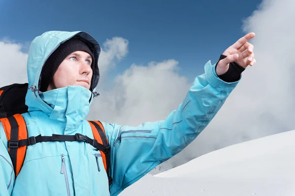 Horolezec, ukazující na vrcholu, stojící proti zimní horské krajiny. — Stock fotografie