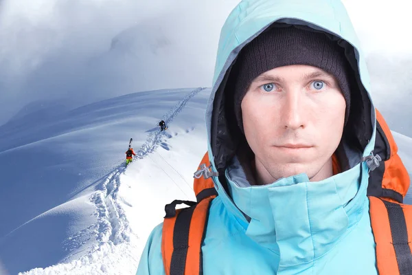 Альпинист с рюкзаком на фоне горных пейзажей. Смотреть в камеру . — стоковое фото