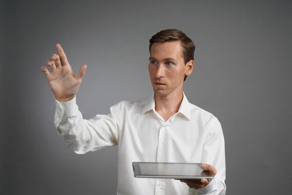 Jeune homme avec tablette fonctionne avec une interface virtuelle . — Photo
