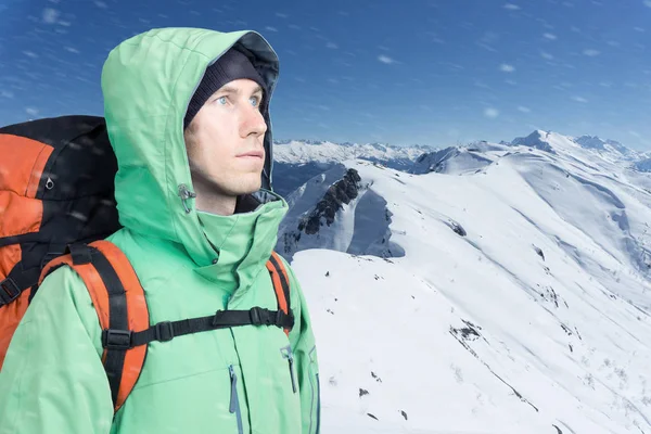 Homem alpinista olha para cima contra uma paisagem de montanha de inverno . — Fotografia de Stock