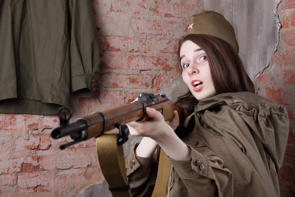 Une femme en uniforme militaire russe tire avec un fusil. Soldat féminin pendant la Seconde Guerre mondiale . — Photo