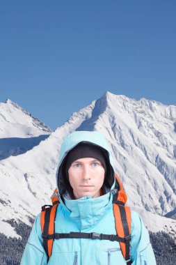 Alpinist adam dağ manzarası bir arka plan üzerinde bir sırt çantası ile. Kameraya bakarak.