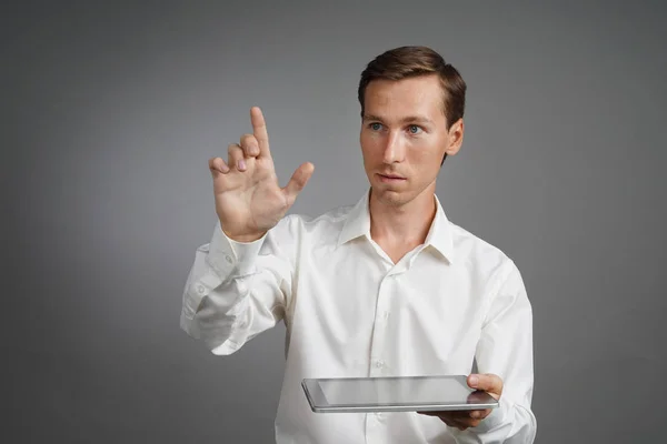 Jeune homme avec tablette fonctionne avec une interface virtuelle . — Photo