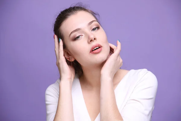 Portret van een leuke Kaukasische vrouw op violette achtergrond. — Stockfoto