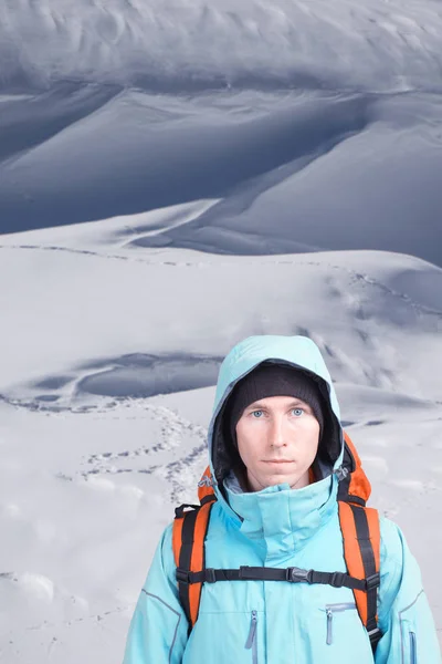 Mladý muž cestovatel stojící na zasněženou plání s stopy ve sněhu. — Stock fotografie