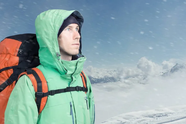 Muž alpinista vypadá proti zimní horské krajiny. — Stock fotografie