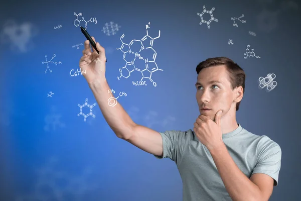 Cientista homem com caneta ou caneta trabalhando com fórmulas químicas em fundo azul . — Fotografia de Stock