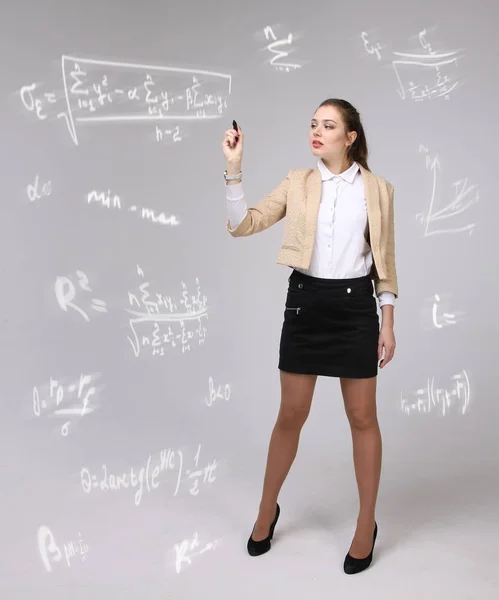 Donna scienziata o studentessa che lavora con varie formule di matematica e scienze del liceo . — Foto Stock