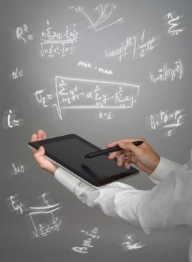 Adam bilim adamı ya da tablet Pc tutarak ve çeşitli lise matematik ve bilim formüllerle çalışma öğrenci.