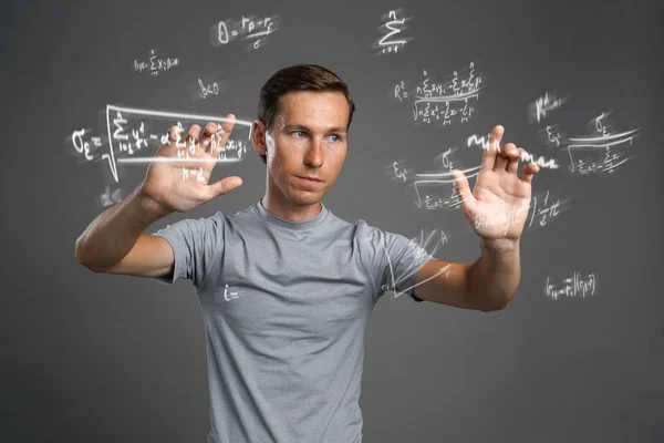 Homme scientifique ou étudiant travaillant avec diverses formules de mathématiques et de sciences au secondaire . — Photo