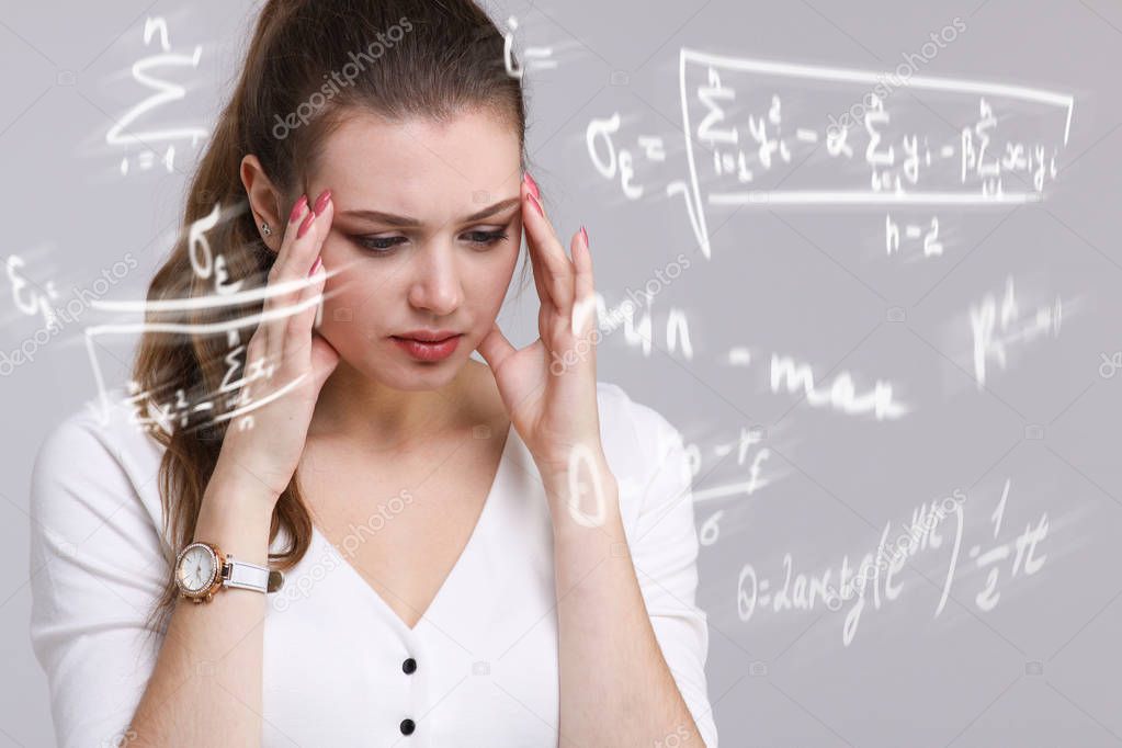 Woman scientist or student working with various high school maths and science formula.