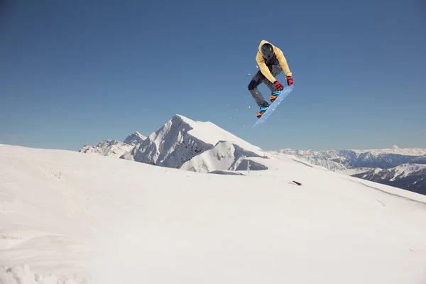 Snowboarder springen in de bergen. Extreme sporten. — Stockfoto