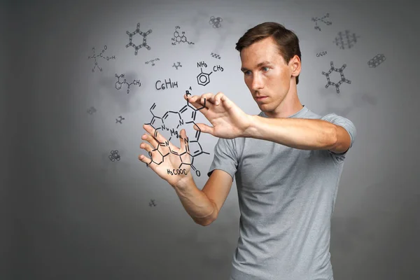 Mannen vetenskapsman i vit skjorta arbetar med kemiska formler på grå bakgrund. — Stockfoto