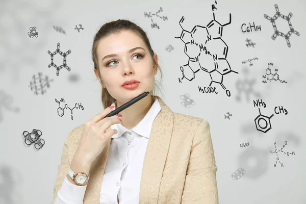 Kimiawan wanita bekerja dengan rumus kimia pada latar belakang abu-abu . — Stok Foto