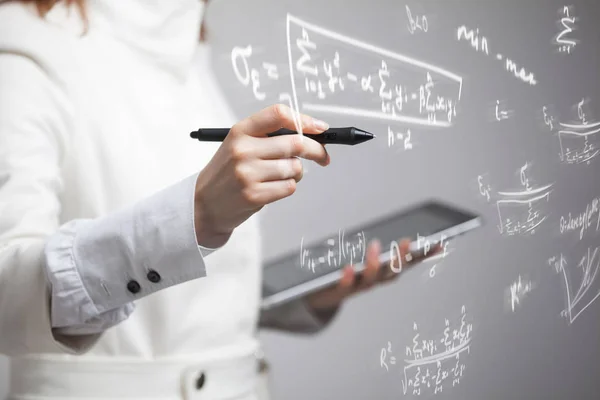 Donna scienziata o studentessa che lavora con varie formule di matematica e scienze del liceo . — Foto Stock