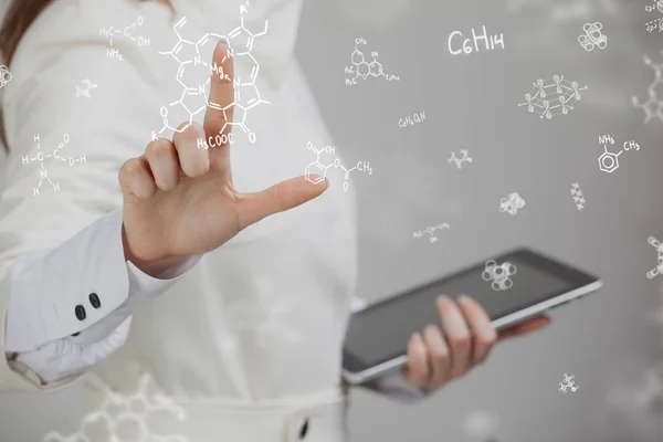 Mujer química trabajando con fórmulas químicas sobre fondo gris . — Foto de Stock