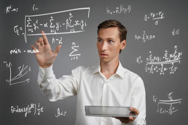Ο άνθρωπος επιστήμονας ή φοιτητής που λειτουργεί με διάφορους τύπους μαθηματικών και θετικών επιστημών γυμνασίου. — Φωτογραφία Αρχείου