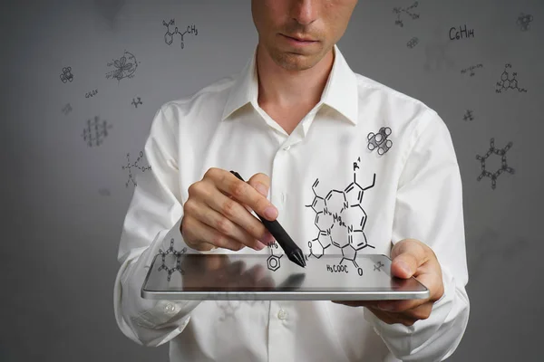 Uomo scienziato con tablet pc e stilo o penna che lavora con formule chimiche su sfondo grigio . — Foto Stock