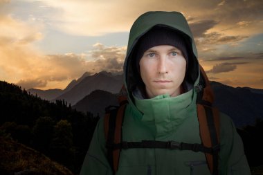 Sırt çantası dağ günbatımı arka plan üzerinde olan adam. Hiking.