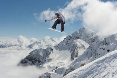 Dağlarda uçan snowboardcu. Olağanüstü kış sporu.