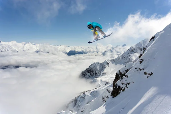 Ιπτάμενος snowboarder στα βουνά. Ακραίο χειμερινό άθλημα. — Φωτογραφία Αρχείου