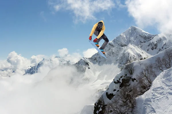 Volando snowboarder en las montañas. Extremo deporte de invierno. — Foto de Stock