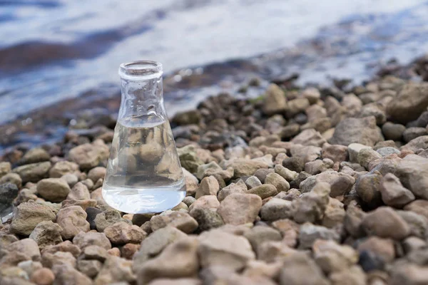 Pallone chimico con acqua, lago o fiume sullo sfondo . — Foto Stock