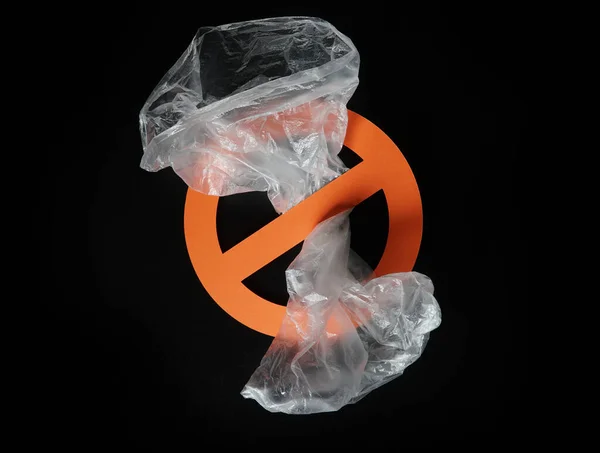 Leere Plastiktüte in einem Stoppschild auf schwarzem Hintergrund. Konzept der Plastikverschmutzung, globale Erwärmung, Recycling von Kunststoff, plastikfrei. — Stockfoto