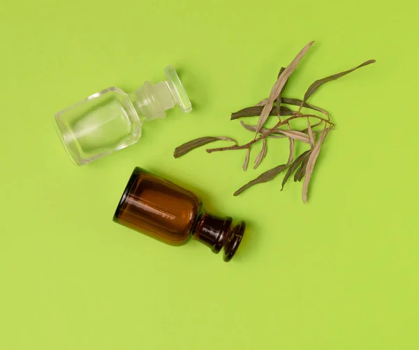干草和两个绿色背景的空瓶子。 草药，精油。 替代医学概念。 带有复制空间的背景. — 图库照片