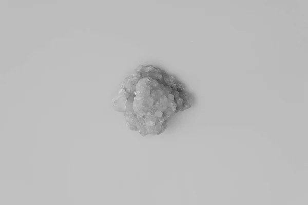 Bílý křišťálový kámen na bílém pozadí zblízka. Chemická sloučenina, krása a lázeňská léčba koncepce — Stock fotografie