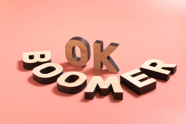 OK Boomer. Internet meme popular among young people. Wooden words on pink background. Royalty Free Stock Images