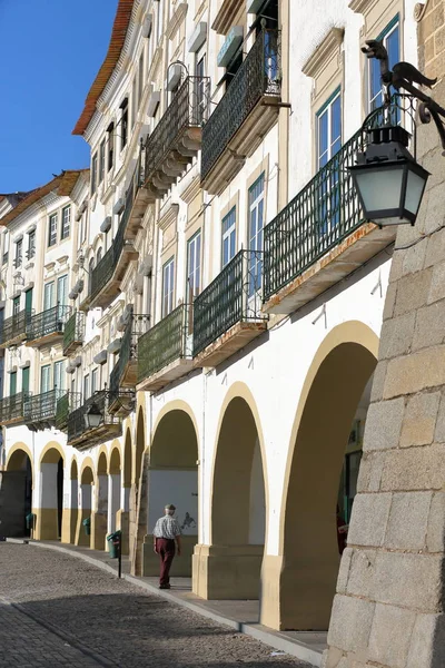 Evora, Portekiz - 8 Ekim 2016: Ön planda sokak lambası şeklinde tipik ev cephe ve bir ejderha ile Giraldo Meydanı'nda arcades — Stok fotoğraf