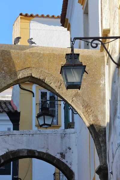 EVORA, PORTUGAL: Close-up em lâmpadas de rua e arcos em uma rua estreita — Fotografia de Stock