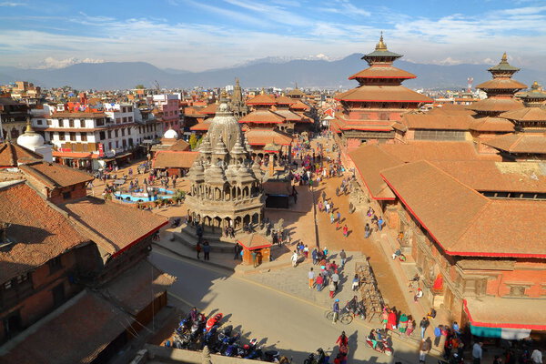PATAN, NEPAL - DECEMBER 20, 2014: General view of the temples at Durbar Square with the Himalayan mountains in the background, Patan, Nepal