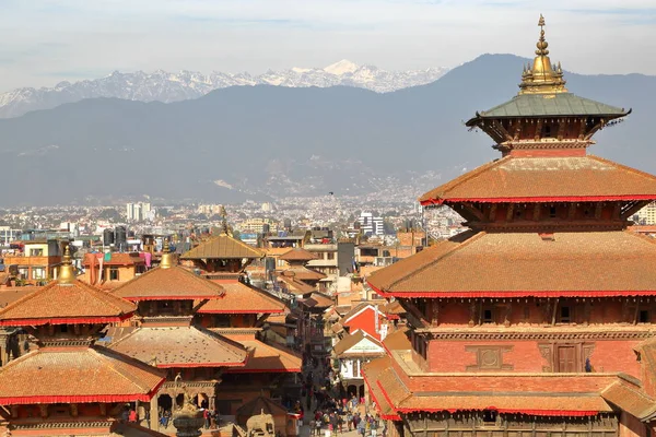 Patan, Nepal: Daken van de tempels in Durbar Square met het Himalaya-gebergte op de achtergrond — Stockfoto
