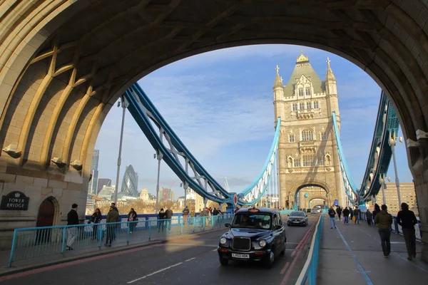 Londyn, Wielka Brytania - 16 stycznia 2016: Czarne taksówki na Tower Bridge z korniszon w tle — Zdjęcie stockowe