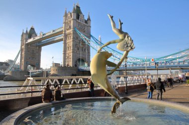 Londra, İngiltere - 11 Aralık 2016: Tower Bridge St Katharine den görünümünü ön planda bir yunus çeşme ile arka plan ve kız 