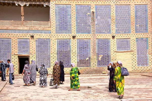 KHIVA, UZBEKISTÁN - 3 DE MAYO DE 2011: Mujeres uzbekas caminando por el patio del palacio Tosh Hovli —  Fotos de Stock