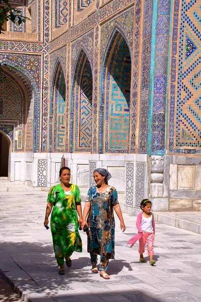 Semerkand, Özbekistan - 17 Mayıs 2011: İki Özbek kadın ve Registan adlı bir medrese avlusunda yürüyen küçük bir kız 