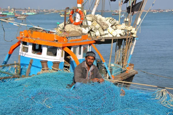DWARKA, GUJARAT, INDIA - 26 DE DICIEMBRE DE 2013: Pescador trabajando en su red de pesca en la isla Bet Dwarka, cerca de Dwarka — Foto de Stock