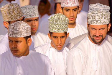 Nizwa, Umman - 3 Şubat 2012: keçi Pazar katılıyor geleneksel olarak giyinmiş Omani erkekler 
