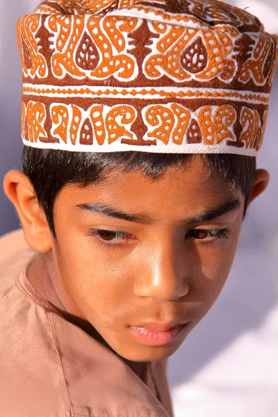 NIZWA, OMAN - 3 FÉVRIER 2012 : Portrait d'un petit garçon omanais vêtu traditionnellement au marché aux chèvres — Photo