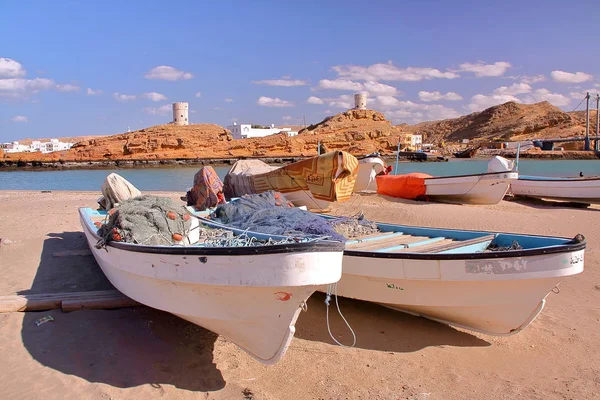 Sur, Oman - 7 februari 2012: Fiskebåtar i Ayjah, Sur med klocka torn i bakgrunden — Stockfoto
