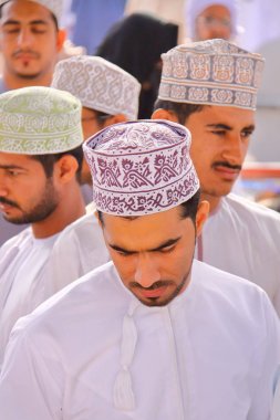 Nizwa, Umman - 3 Şubat 2012: keçi piyasada Nizwa katılıyor geleneksel olarak giyinmiş Omani erkekler