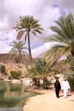 WADI BANI KHALID, OMAN - FEBRUARY 5, 2012: An Omani couple visiting Wadi Bani Khalid in Sharqiya clipart