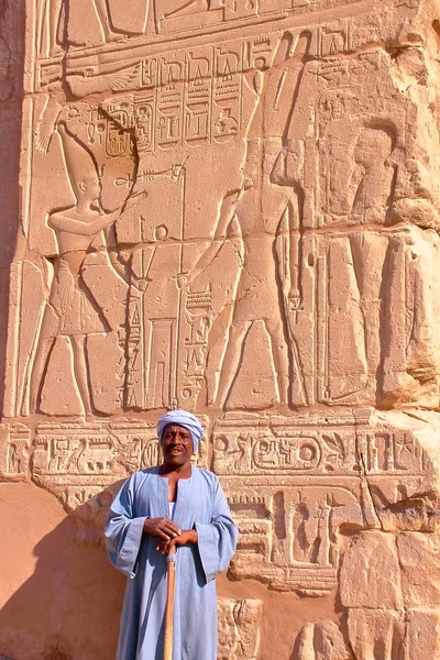 LUXOR, EGITO - NOVEMBRO 2, 2011: Retrato de um guarda em frente a hieróglifos no templo de Karnak — Fotografia de Stock