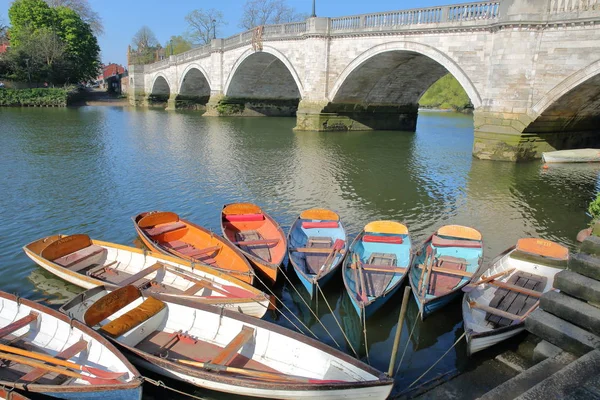 LONDON, UK - APRIL 9, 2017: Colorful boats on the river Thames in Richmond (Southwest London) with Richmond Bridge in the background — Stock Photo, Image
