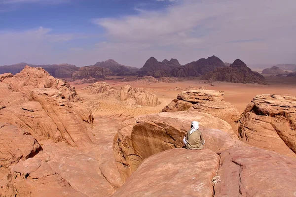 WADI RUM, JORDANIA: Un jordano con vistas al desierto de Wadi Rum desde la cima de una montaña — Foto de Stock