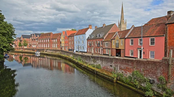 Das Flussufer (river wensum) in norwich (norfolk, uk) mit bunten Häusern und dem Turm und der Kirchturmspitze der Kathedrale im Hintergrund — Stockfoto