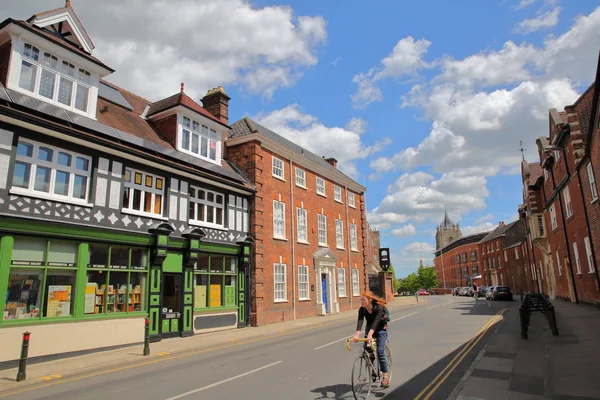 NORWICH, Reino Unido - 4 de junio de 2017: Una joven pelirroja en bicicleta por la calle Bethel con casas coloridas y medievales y un hermoso cielo —  Fotos de Stock